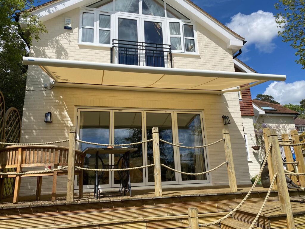 Cream colored patio awning over deck of house