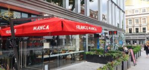 Side view of red giant umbrella of open air restaurant