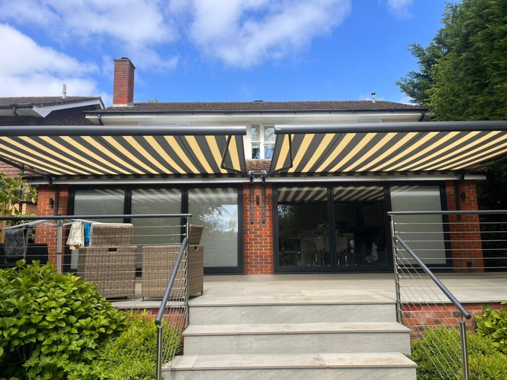 2 black and yellow striped patio awnings side by side closer view