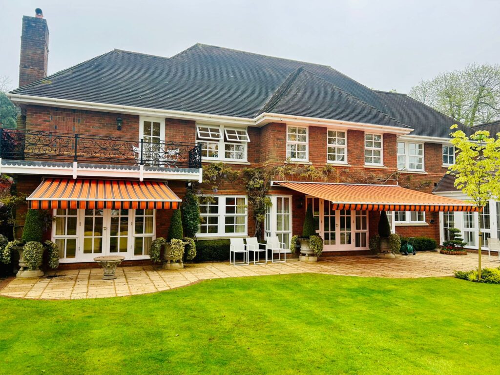 Orange and black stripes patio awnings of large house