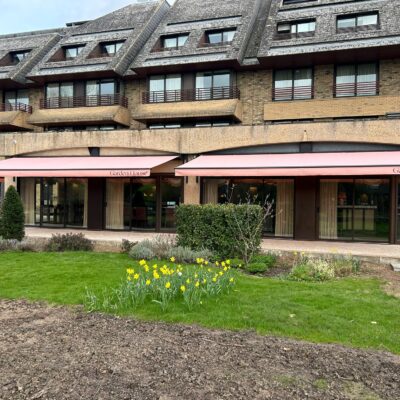 2 wide pink restaurant awnings as seen across a big lawn