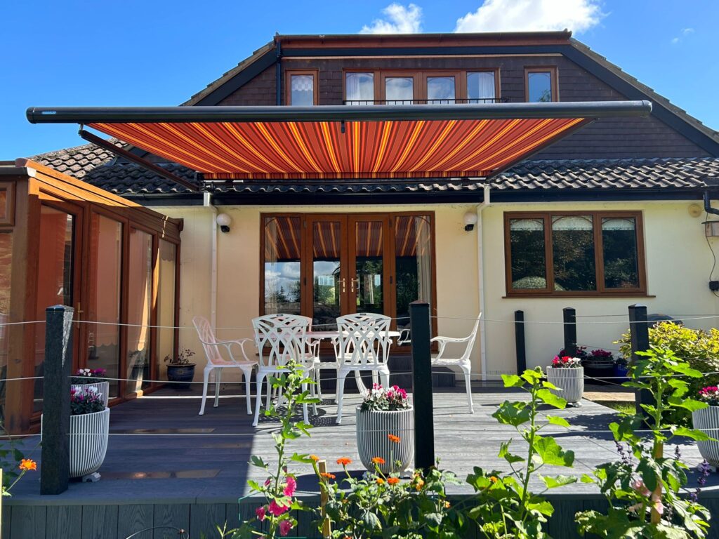 Orange and maroon striped patio awning of house