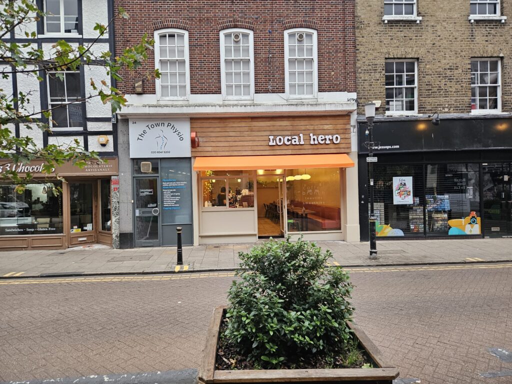 Another front view of orange canopy of restaurant as seen across the street