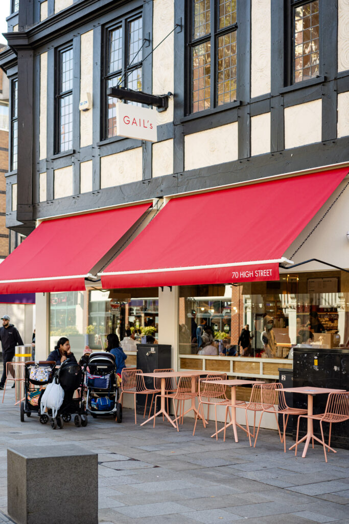 2 red restaurant awnings as seen across the street