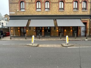 3 grey shop awnings in row of grocery